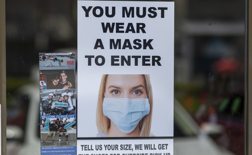 Masks are required for entry to a shoe store in Glendale, Calif. Most people follow guidelines to wear masks when they enter retail stores and restaurants, but some customers don't comply.