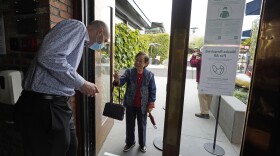 Host Jason Pryor checks the vaccination record of Audrey Tong as she enters the Waterbar restaurant on Aug. 20, 2021, in San Francisco.