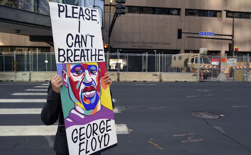 A protester holds a sign across the street from the Hennepin County Government Center in Minneapolis on April 6 during the trial of former police officer Derek Chauvin. The testimony ran for three weeks.