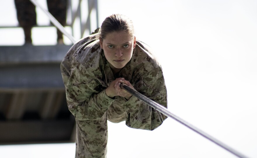 A female Marine recruit climbing down the rope in the Slide for Life obstacle course at Marine Corps Recruit Depot, San Diego, March 9, 2021.