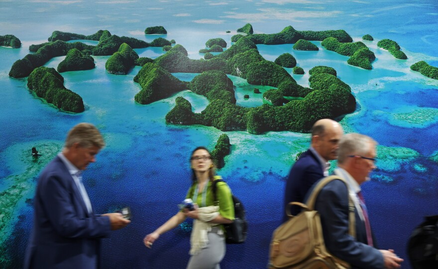 Conference attendees walk past the Mona Blue Pacific Pavilion at the conference.