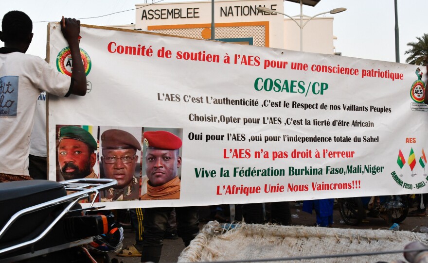 Supporters of the Alliance Of Sahel States (AES) hold up their banner as they celebrate Mali, Burkina Faso and Niger leaving the Economic Community of West African States (ECOWAS) in Niamey on January 28, 2024.