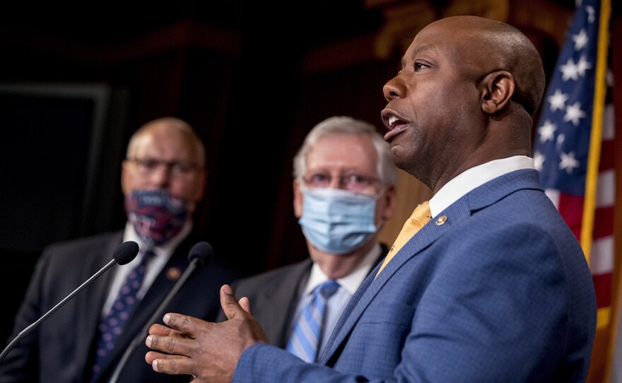 Sen. Tim Scott, R-S.C.,  right, addresses a news conference Wednesday to announce a Republican police reform bill on Capitol Hill.