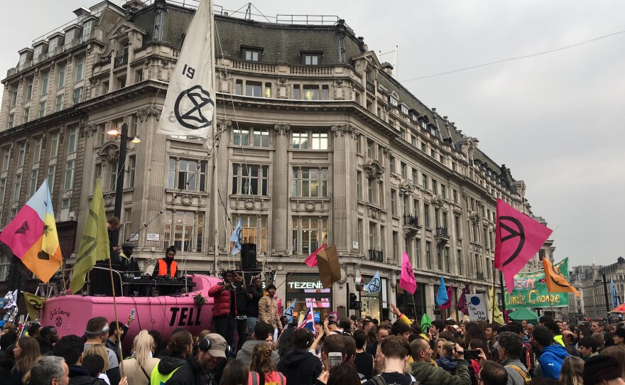 A pink sailboat at a tent camp blocks traffic in London's Oxford Circus on Tuesday. Protesters chose a sailboat to illustrate the threat of rising waters. They want Britain to reduce greenhouse gas emissions to net zero by 2025.