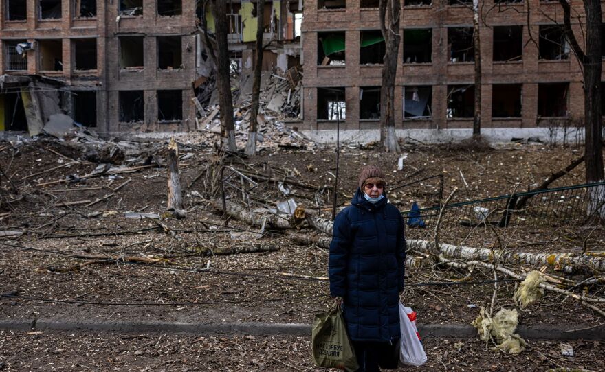 A woman stands in front of a destroyed building after a Russian missile attack in the town of Vasylkiv, near Kyiv, on Feb. 27.