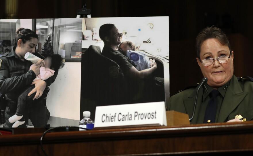 U.S. Border Patrol Chief Carla Provost testifies by a photo of agents with children during a Senate Judiciary Border Security and Immigration Subcommittee hearing.