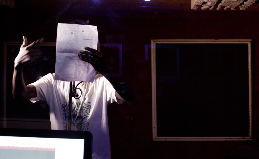 A member of the up-and-coming group Carre D'as records in a studio on the outskirts of Dakar. The group's name means "ace cards."