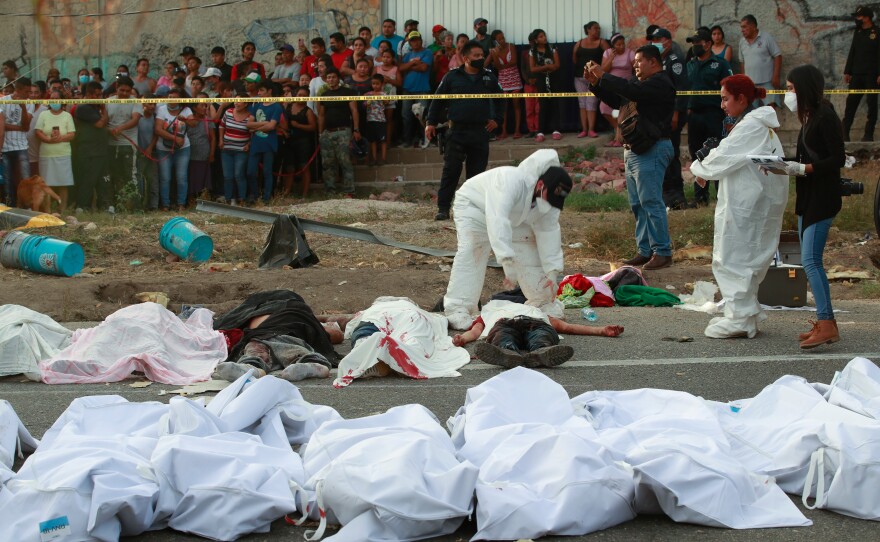 Bodies in bags sit on the side of the road after a deadly semi-trailer truck crash in Tuxtla Gutierrez, Chiapas state, Mexico, Dec. 9, 2021.