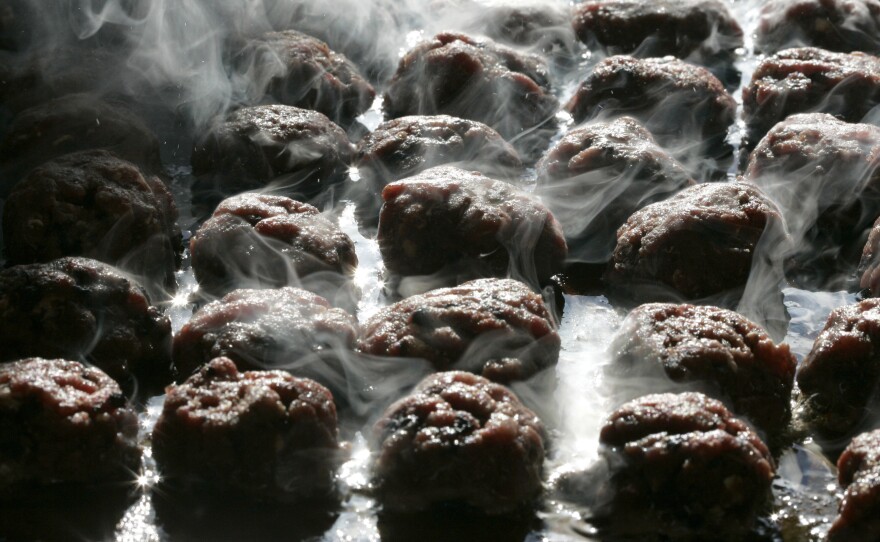 Moose patties sweetened with blueberries cook on the grill before the start of the Wild Game Supper.