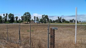 The site for the Bella Mar Apartments project is seen behind a chain link fence, Aug. 15, 2025.