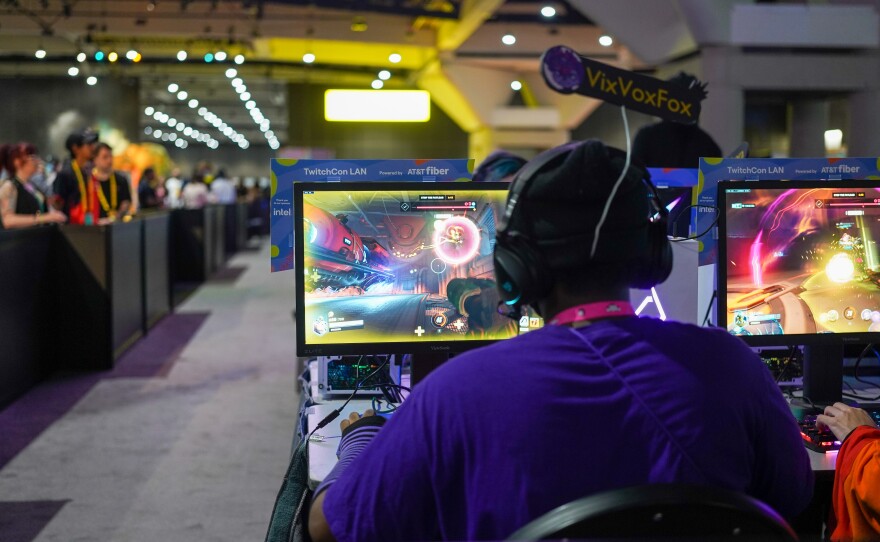 A convention attendee plays a video game at the TwitchCon LAN on Oct. 8, 2022. 