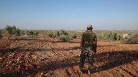 A senior Uyghur militant stands in an olive grove in northern Syria, where Uyghur commanders say their fighters began an ultimately successful assault on Syrian regime forces in November 2024.
