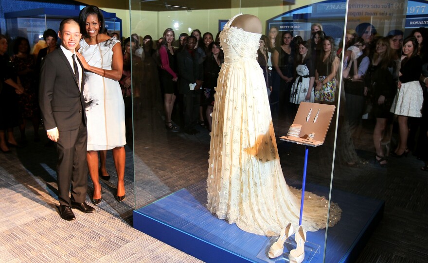 The First Lady and fashion designer Jason Wu stand next to the gown she wore to the inaugural balls at the Smithsonian Museum of American History on March 9, 2010 in Washington, D.C. Mrs. Obama continues a long tradition of first ladies who have donated their inaugural gown to be on display at the Smithsonian.