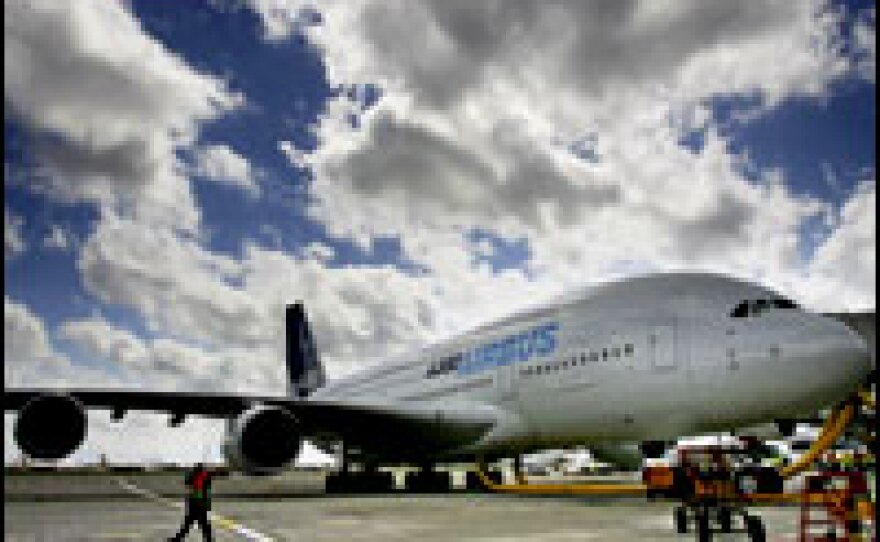 An Airbus A380, the world's largest passenger aircraft, sits in the terminal at Heathrow Airport. The A380's twin-aisle, twin-deck passenger cabin includes wide seats and aisles. An optional lower deck includes rest areas and a bar. 