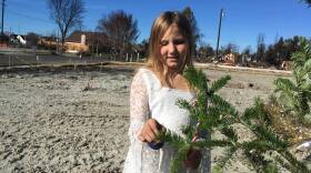 Lilly Pell decorates a Christmas tree where the front door of her house used to be. It was destroyed in the North Bay wildfires.