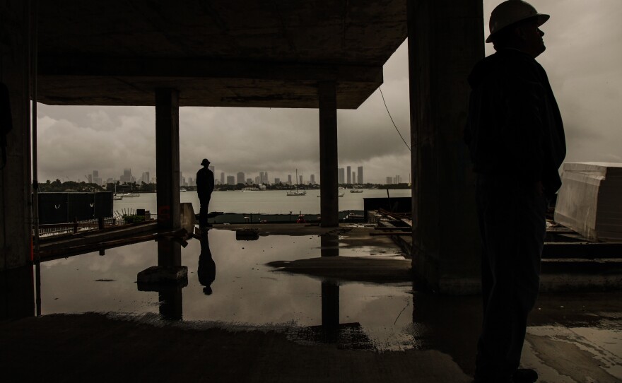At the construction site, Koster explains how Monad Terrace is designed to address buyers' climate change concerns. The base of the building is 12 feet off the ground, and a landscaped ramp will lead residents up and away from future floodwaters.