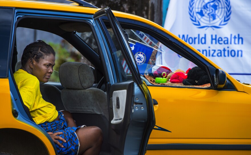 A pregnant woman waits for help in a cab outside John F. Kennedy hospital in Monrovia, Liberia, September 15. Then closed, the hospital's maternity ward reopened in October and is now one of the few places in Monrovia delivering babies.