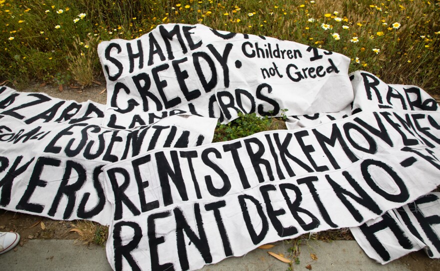 Signs for a rent strike caravan lay on the ground before protesters drove through San Diego as part of a statewide effort on May 1, 2020.