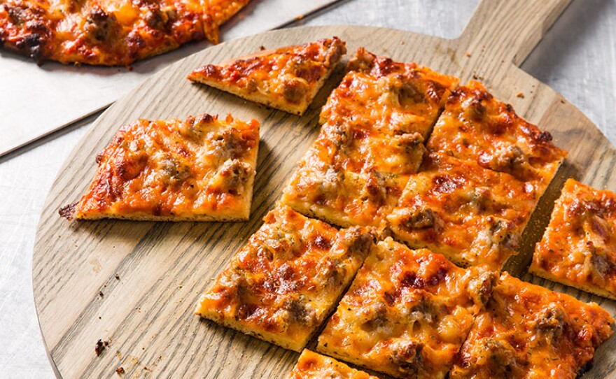 Test cook Bryan Roof cooks Julia Collin Davison a surprising Italian classic: Chicago Thin-Crust Pizza with Homemade Italian Sausage.