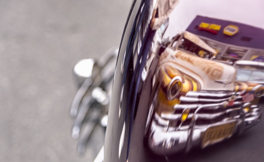 Shiny bumpers on one lowrider reflect another lowrider at the celebration for the removal of National City’s last “Cruising Prohibited” sign, National City, May 19, 2023.