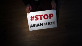 In this March 31, 2021, file photo, Jen Ho Lee, a 76-year-old South Korean immigrant, poses in her apartment in Los Angeles with a sign from a recent rally against anti-Asian hate crimes she attended.