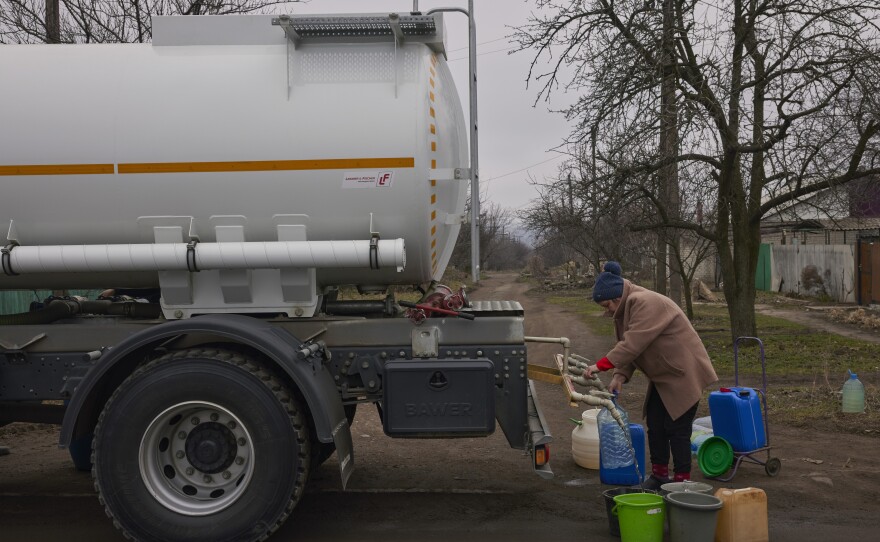 A local resident fills buckets and bottles with water from a water truck on March 20, 2023 in Konstantinivka, Ukraine. The UN says millions of Ukrainians have lost access to clean water.