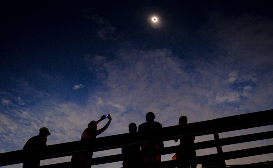 Eclipse gazers enjoying totality on August 21, 2017, in Isle of Palms, S.C. Eclipse experts say partial eclipses aren't nearly as dramatic.