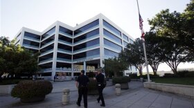 San Diego police officers head into the headquarters building where the flag flies at half-mast in this file photo from Oct. 28, 2010.