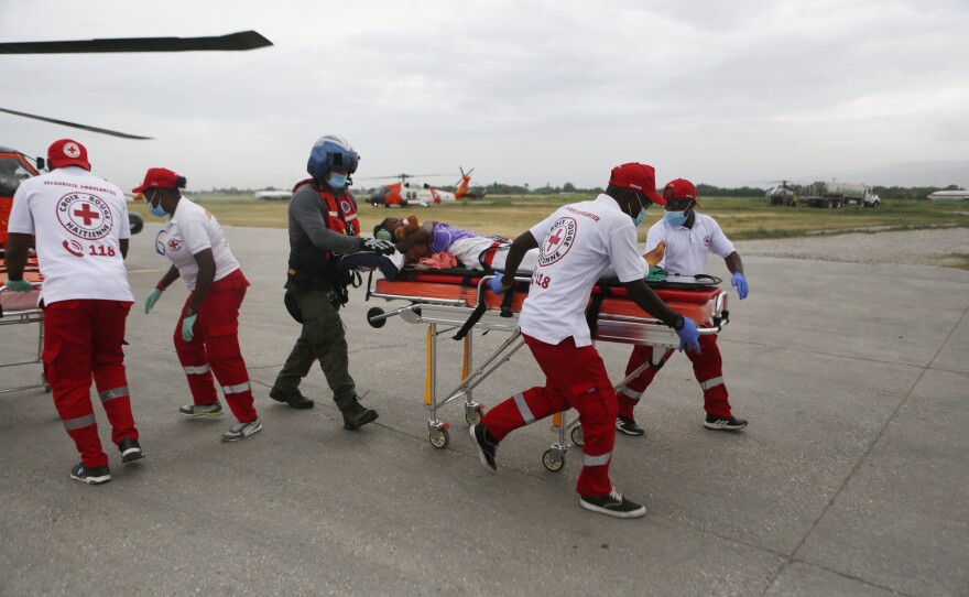 The U.S. Coast Guard and the Haitian Red Cross transport a patient to a tent hospital to be treated for their injuries sustained in the recent 7.2 magnitude earthquake, at the Toussaint Louverture International Airport, in Port-Au-Prince on Wednesday.