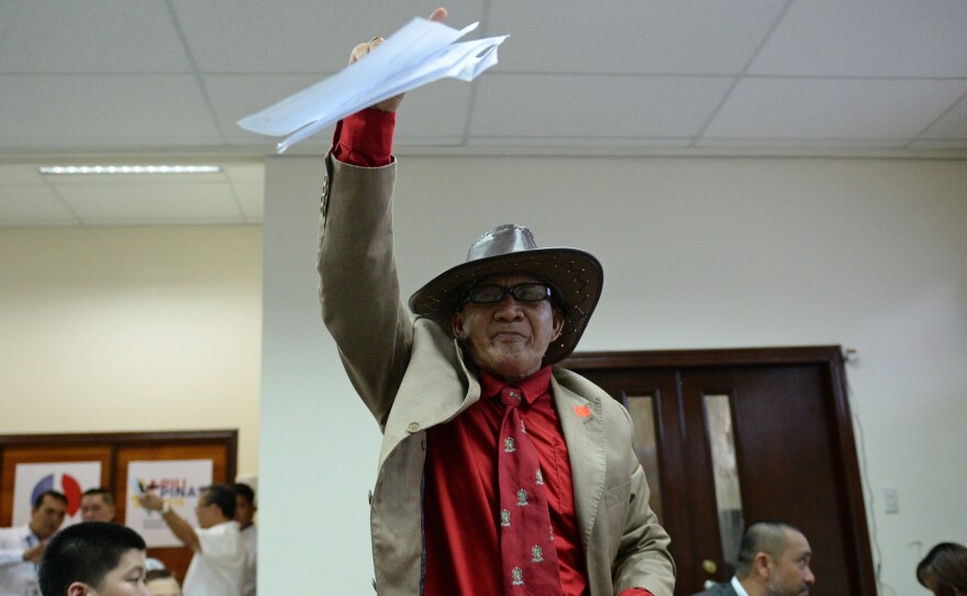 Ephraim Defino waves his candidacy certificate after filing as a presidential candidate at Manila's election commission. So-called "nuisance" candidates are a staple of the Southeast Asian nation's chaotic democracy.