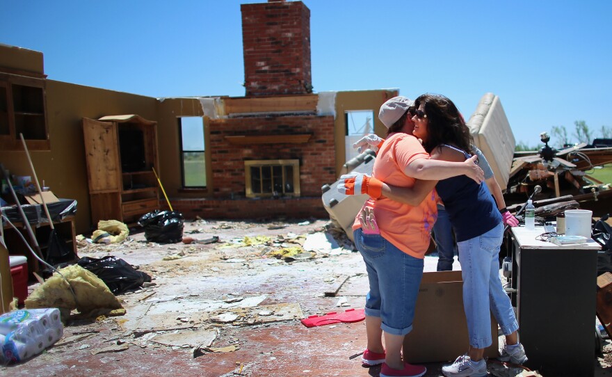 Tammy Wade (left) is hugged by Dana Givens in what is left of her home in El Reno, Okla., on Sunday, after it was destroyed by a tornado.