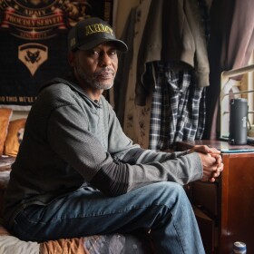 Calvin Neal sits inside his single-room occupancy at the Hotel Churchill in downtown San Diego on Friday, Oct. 3, 2025.