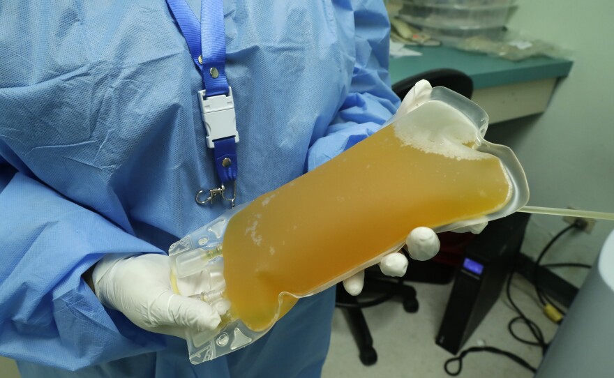 A doctor holds a donation of convalescent plasma from a recovered COVID-19 patient in this May 13, 2020, file photo.