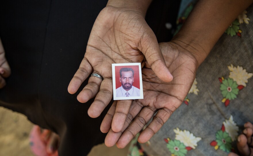 Sargunarasa went missing with his neighbor Seliyyah on July 5, 2006, while on a business trip. His wife, Malar, and Shalini, their only daughter, hold his passport image.