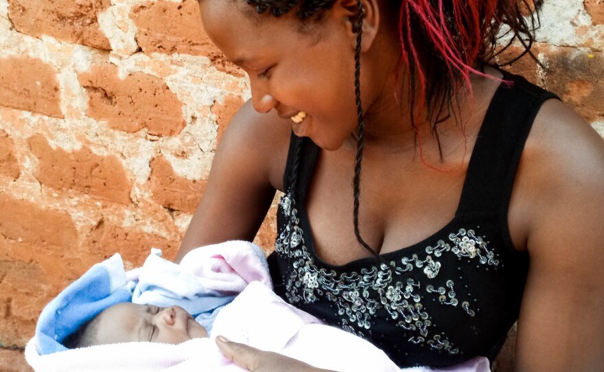 Maria Nalubega holds her three-week-old baby daughter.