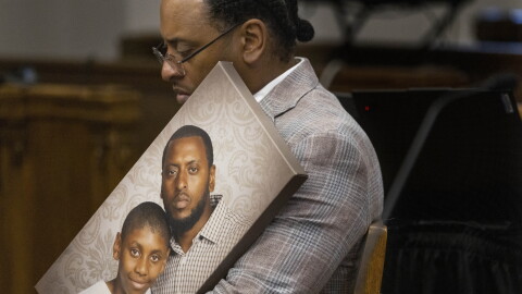 Antonio Mays Sr. holds a picture of himself and his son, Antonio Mays Jr., in Superior Court at the King County Courthouse in Seattle on Dec. 10, 2025.