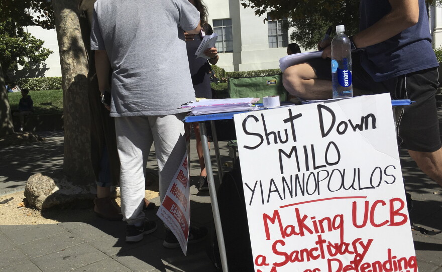 In this Sept. 21, 2017 photo, a group has put up flyers and a booth on Sproul Plaza calling for protesters to "Shut Down Milo Yiannopoulos," at the University of California, Berkeley campus in Berkeley, Calif.