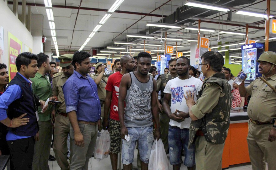 Indian police and onlookers surround African nationals at a shopping mall in Greater Noida.