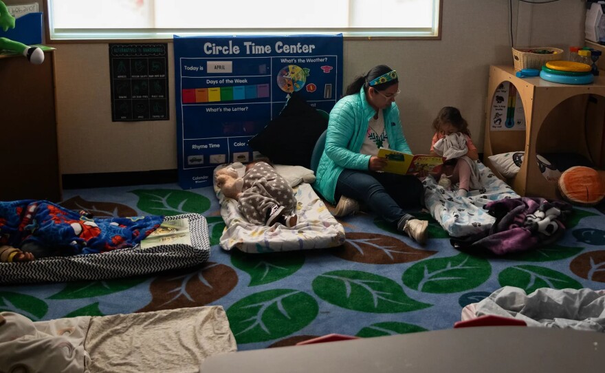 Teacher Ismairy Caldera reads to a student to help them fall asleep during nap time at Mi Escuelita in San Diego on May 5, 2025. Nap time can be particularly challenging for children who have experienced trauma, as many of them remain on high alert and struggle to rest.
