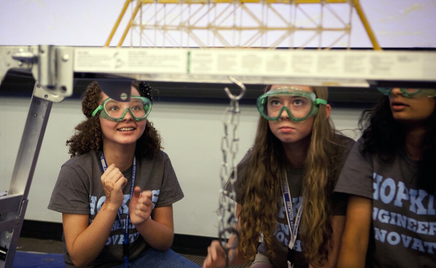 Sheidey Morales Del Valle (left), Amelia Hawley and Varsha Gopal of Team Foxy Epoxy try sending their bridge subliminal messages, willing it to hold up under pressure.
