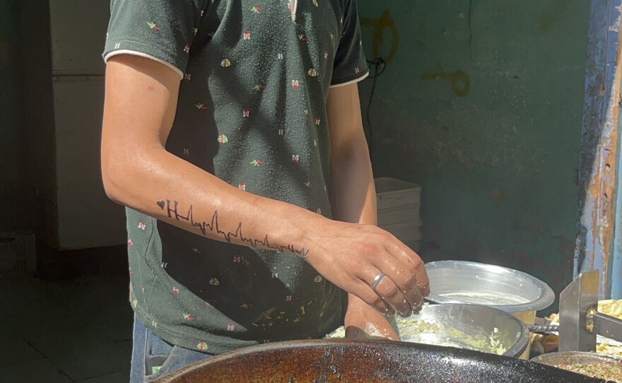 21-year-old Yousef Ahmed fries taamiya at a food cart in Cairo.