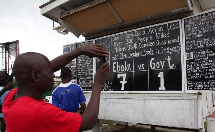 Liberians read the Daily Talk chalk board on the Ebola outbreak situation in the capital Monrovia, Liberia, on Saturday. According to statistics from the World Health Organisation (WHO) 959 patients have died from Ebola in West Africa.