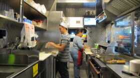 Employees at work inside the Tacos La Doña taco truck.