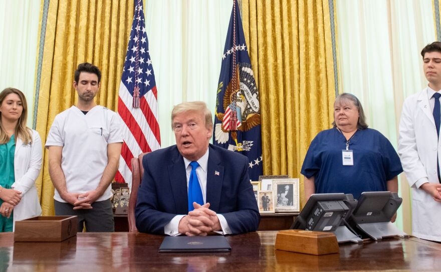 President Trump speaks about COVID-19 alongside nurses after signing a proclamation in honor of National Nurses Day in the Oval Office of the White House on Wednesday. Trump and Vice President Pence have not worn face masks during public events, which goes against the administration's recommendations.