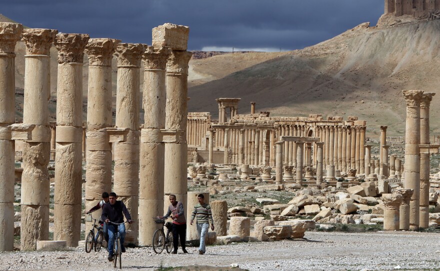 Syrian citizens ride their bicycles in Palmyra in March. Authorities in Lebanon say they have seized many looted items from Syria, including 24 statues from Palmyra.