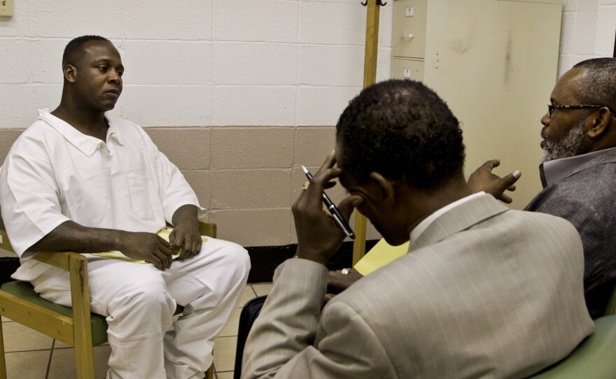 Billy Smith (right) and Johnny Lindsey (center) meet with prisoner Jimmy O'Steen. The group believes O'Steen is innocent and hopes its investigation can exonerate him.