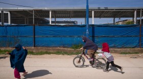 Children ride a bicycle and play in the Roj camp in a Kurdish-held territory in northeast Syria in March. The detention camp houses wives and children of ISIS members.