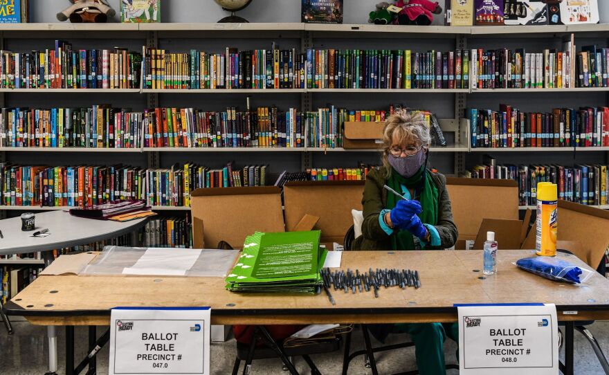 An election worker wears protective gloves during the Florida primary election at South Pointe Elementary School in Miami, on Tuesday.