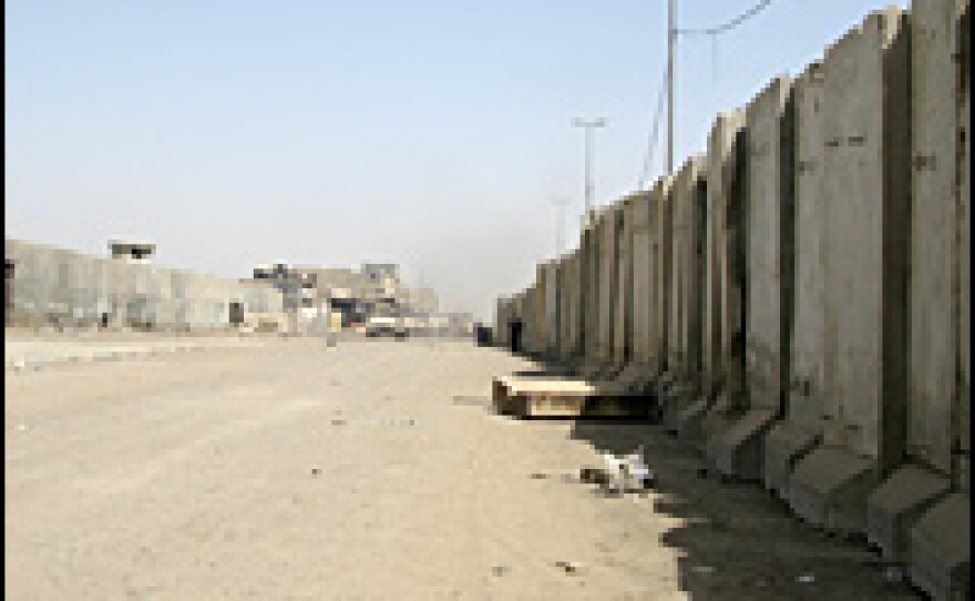 A three-mile-long, 12-foot-high concrete barrier encircles the Jamiila wholesale market in Baghdad's Sadr City neighborhood. The market used to be the biggest in Iraq; now merchants say the wall blocks reconstruction efforts and customers.