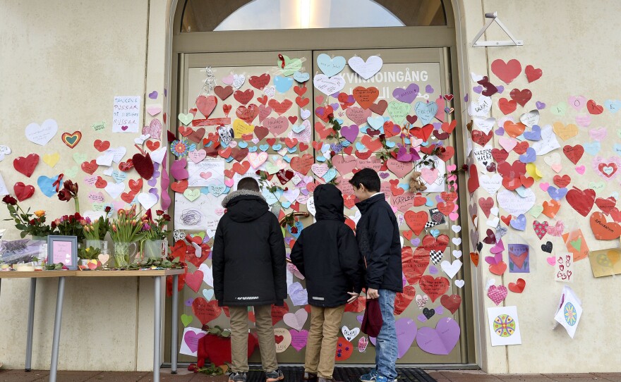 Boys read messages posted on the entrance of a mosque in Uppsala by neighbors pledging their support last month.